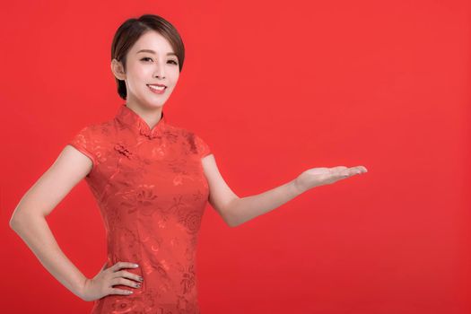 Happy Chinese new year. Asian woman wearing traditional cheongsam  dress with gesture of introduce