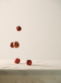 Falling red apples on table background