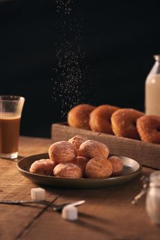 Small balls of freshly baked homemade cottage cheese doughnuts in a plate on a gray background. 