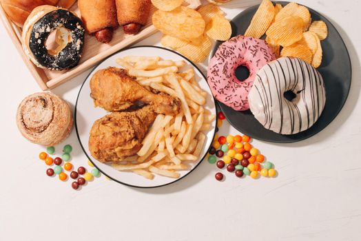 fast food and unhealthy eating concept - close up of fast food snacks and cola drink on white table 
