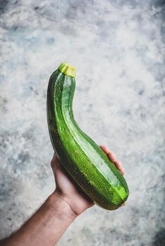 Hand holding zucchini