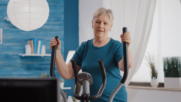 Elder adult doing cycling exercise on stationary bicycle