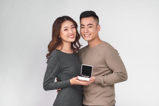 Asian man gives jewelry in a box to his woman