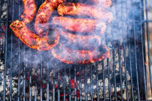 Grilling sausages on barbecue grill. Delicious sausages on charcoal grill