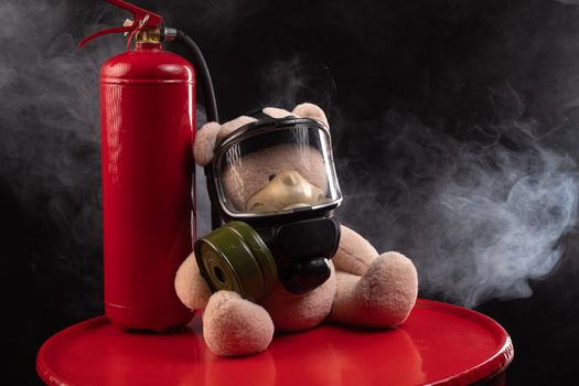 the mascot of the fire brigade is a teddy bear in a gas mask with a fire extinguisher in smoke on a dark background