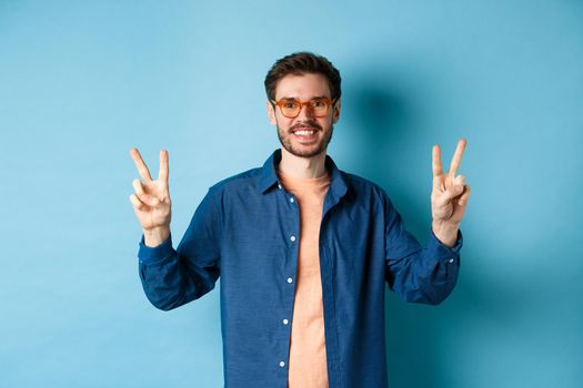 Cheerful guy posing with peace sign in new glasses, concept of eyewear shop promotion