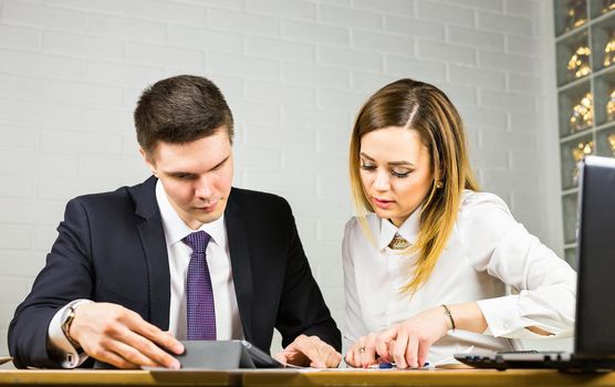 Businesspeople With Digital Tablet Sitting In Modern Office