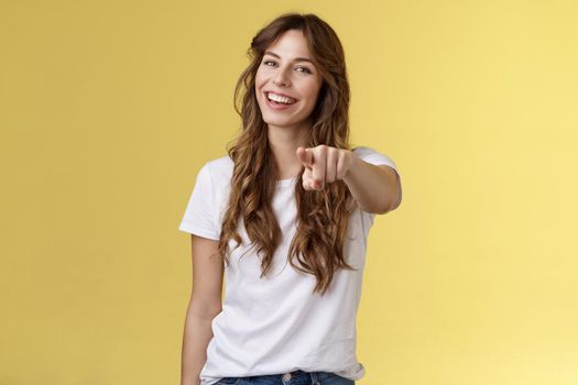 Hey you congrats. Joyful good-looking friendly enthusiastic lovely girl laughing happily pointing camera joking picking making choice congratulate excellent job stand yellow background smiling