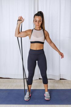 Active woman doing bicep exercise with resistance band