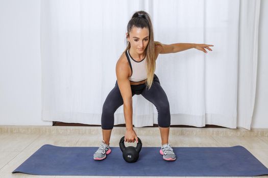Active woman lifting kettlebell during workout