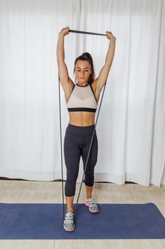 Young woman doing resistance exercise for shoulders