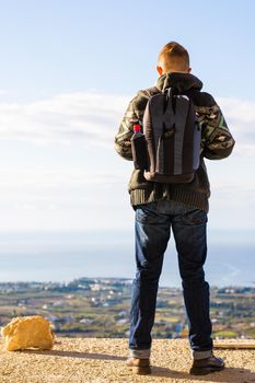 Young hipster man traveling backpacker outdoor. Travel concept.