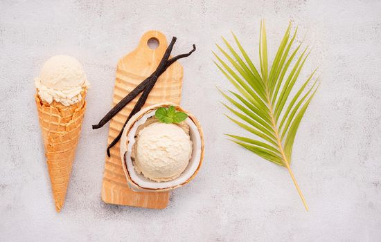 Coconut ice cream flavours in half of coconut setup on white stone background. Summer and Sweet menu concept.