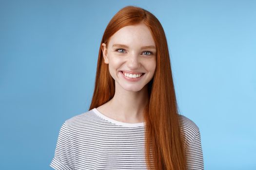 Pleasant reliable sincere good-looking redhead female freelancer college student make confident professional impression smiling broadly assertive helpful standing blue background self-assured