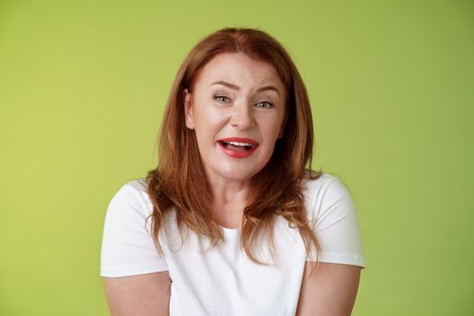Tender redhead cheerful middle-aged mother sighing happiness temptation smiling delighted look alluring fascinated camera check out cute lovely scene melting heartwarming moment green background