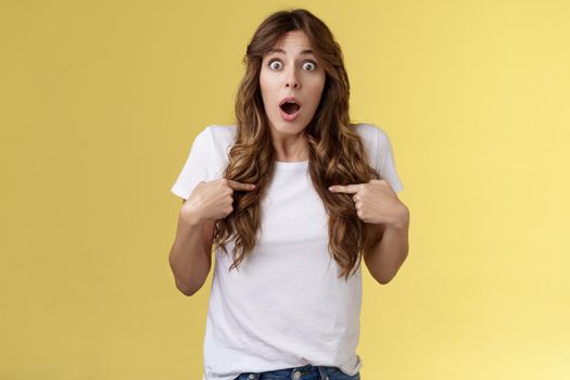 Shocked impressed speechless surprised girl gasping drop jaw pointing herself chest stare camera astonished unexpected promotion being chosen picked winning lottery stand yellow background