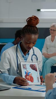 Woman with doctor occupation holding modern tablet