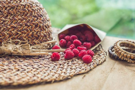 Summer holiday, vacation, relaxation concept. Raspberries, straw hat. Free text copy space. Summer vibes concept