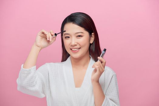 Bautiful asian woman applying mascara