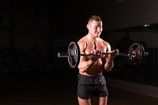 young man doing heavy weight exercise for biceps.