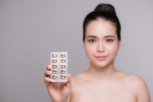 Young woman with pills - focus on pills