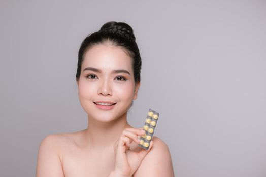 Girl is holding pack of pill with vitamins
