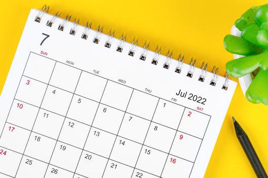 July 2022 desk calendar on yellow background.