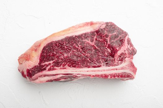 Fresh, huge and appetizing dry aged club steak, on white stone background