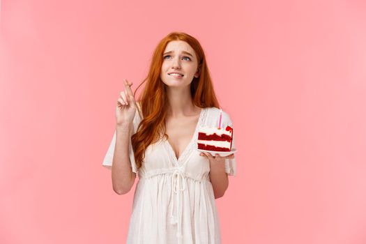 Waist-up portrait intense and wishful cute redhead b-day girl want dream come true badly, frowning intense looking up sky, biting lip and cross fingers good luck, blow candle on birthday cake