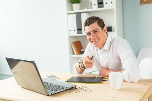 Designer, technologies, people concept - man using graphic tablet in office and looking at you