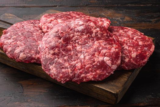 Raw Minced Steak Burgers from Beef Meat, on old dark wooden table background