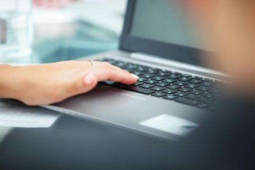 female hand on the keyboard of stylish laptop