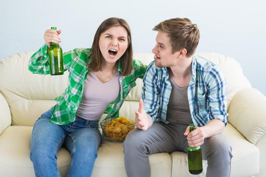 Friends watch sports on TV together, drink beer. Fans cheer for their team.