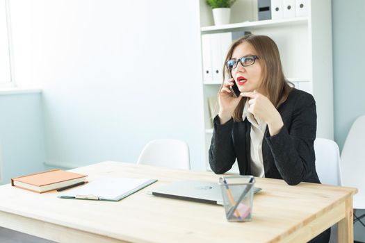 Business, realtor and people concept - Attractive woman in office talking on phone.