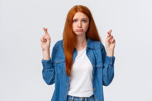 Girl hopes she passed exam. Worried and gloomy, hopeful redhead woman wishing dream come true, aspire something, pouting uneasy, cross fingers good luck, make wish over white background