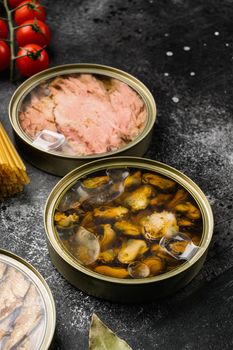Canned fish and seafood in aluminum can, on black dark stone table background