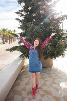 Christmas, holidays, humor and people concept - young happy woman have fun under the christmas tree
