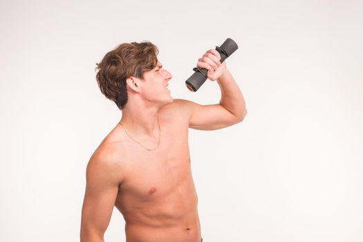 Fitness, joke and people concept - portrait of handsome athletic man singing with dumbbell on white background