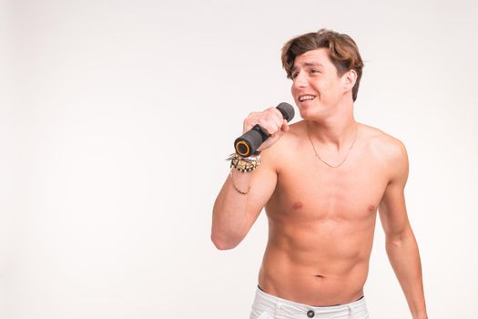 Expression, fitness and gesture concept - Handsome sporty man singing with dumbbell over white background with copy space