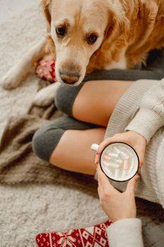 Girl with cocoa and golden retriever dog