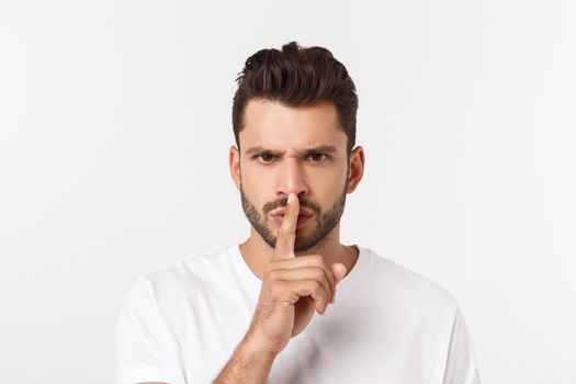 Business man with finger on lips asking for silence over white background