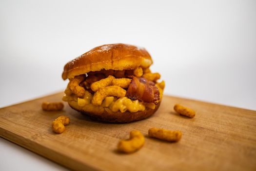 Dish for fat Thursday with big donut with mac and cheese bacon and peanut crisps
