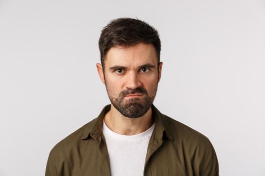 Angry pissed bearded guy losing temper, want kill someone, staring aggressive, trying keep mouth shut and not hit person as feeling rage and aggression, suck lips, frowning staring with scorn