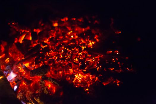 Burning embers of a fire on a black background.