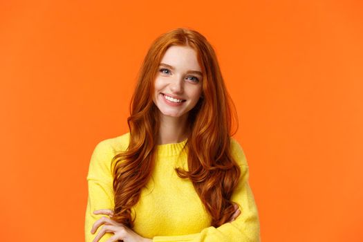 E-commerce, professionalism and employement concept. Cheerful pleasant redhead curly-haired woman in yellow sweater, standing confident with crossed arms and smiling camera