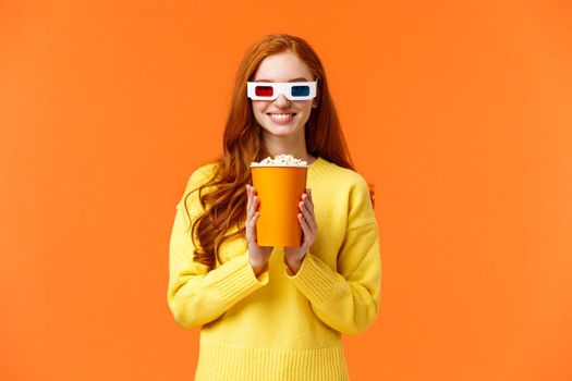 Girl anticipate start of movie, smiling excited, visit cinema, holding popcorn and grinning, wear 3d glasses to watch new fantasy film, like watching premiere in theatre on big screen, orange wall