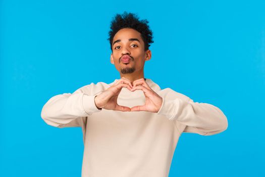 Relationship, romance and feelings concept. Man decided give himself as present for valentines day. Cheeky cute african american boyfriend showing heart sign with love and folding lips to kiss