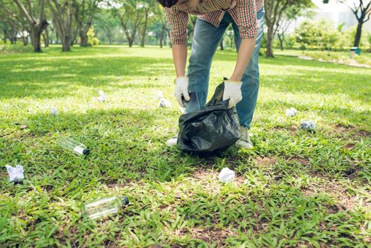 Asian man picking up plastic household waste in park