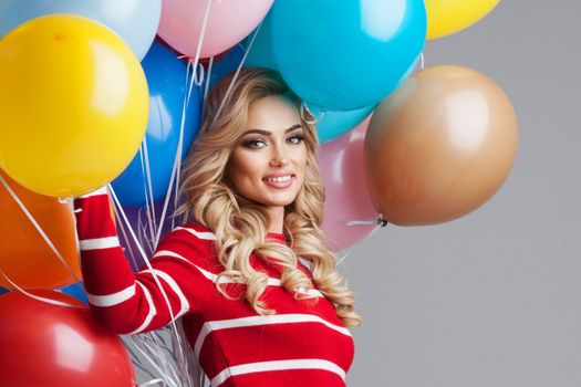 Happy woman with many colorful balloons