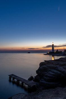 Panoramic HDR Landscape view of Neowise comet over white Lighthouse at night sky